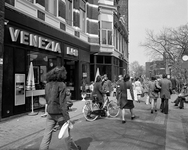 856044 Gezicht op de Oudegracht te Utrecht, ter hoogte van IJssalon Venezia (Oudegracht 105), met winkelend publiek.